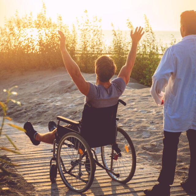 man wheelchair his nurse enjoying sunrise beach