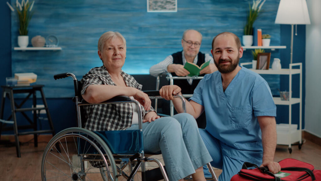 portrait old disabled woman man nurse looking camera nursing home retired patient with chronic issues sitting wheelchair while medical assistant preparing examination